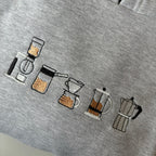 Buzo con cafeteras bordadas