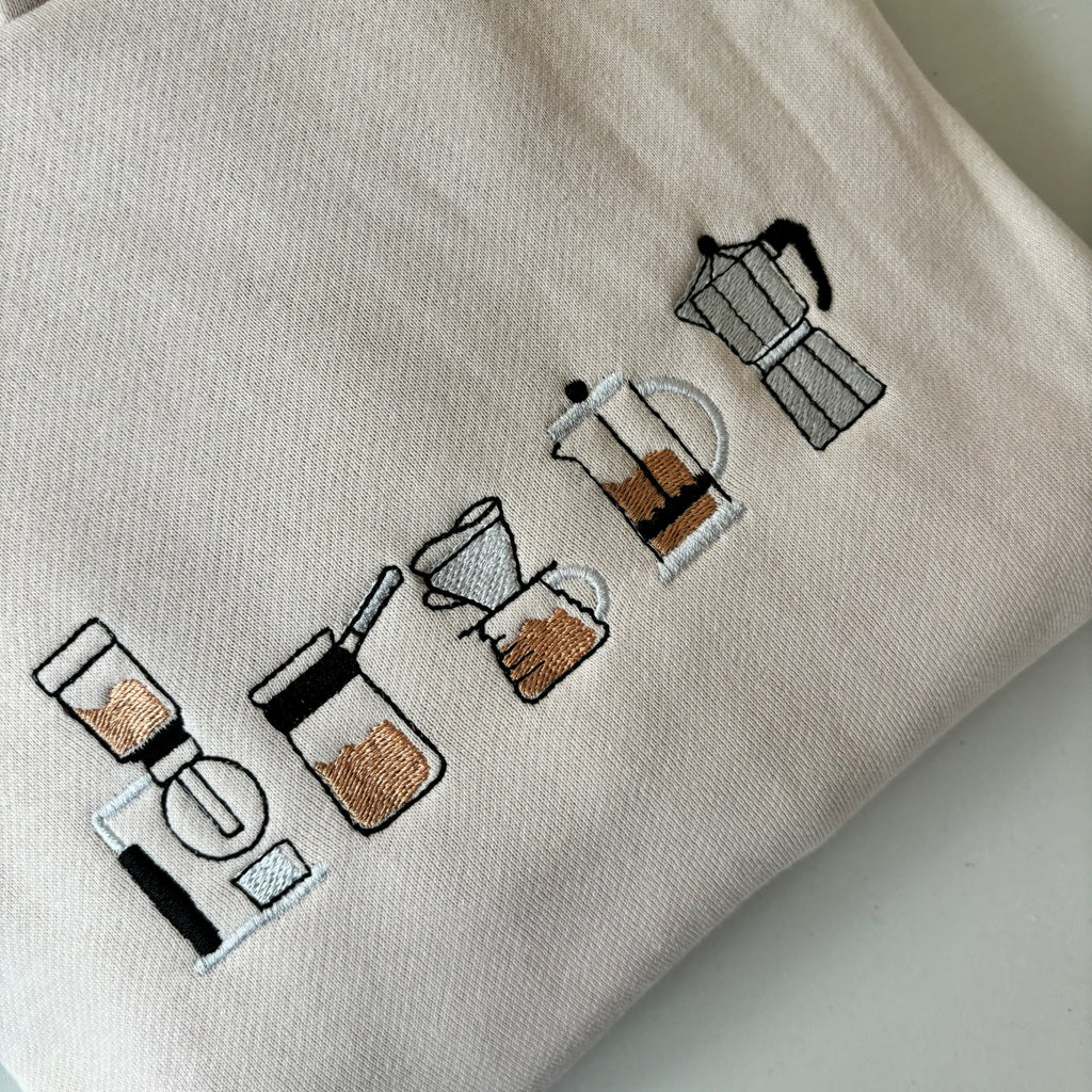 Buzo con cafeteras bordadas